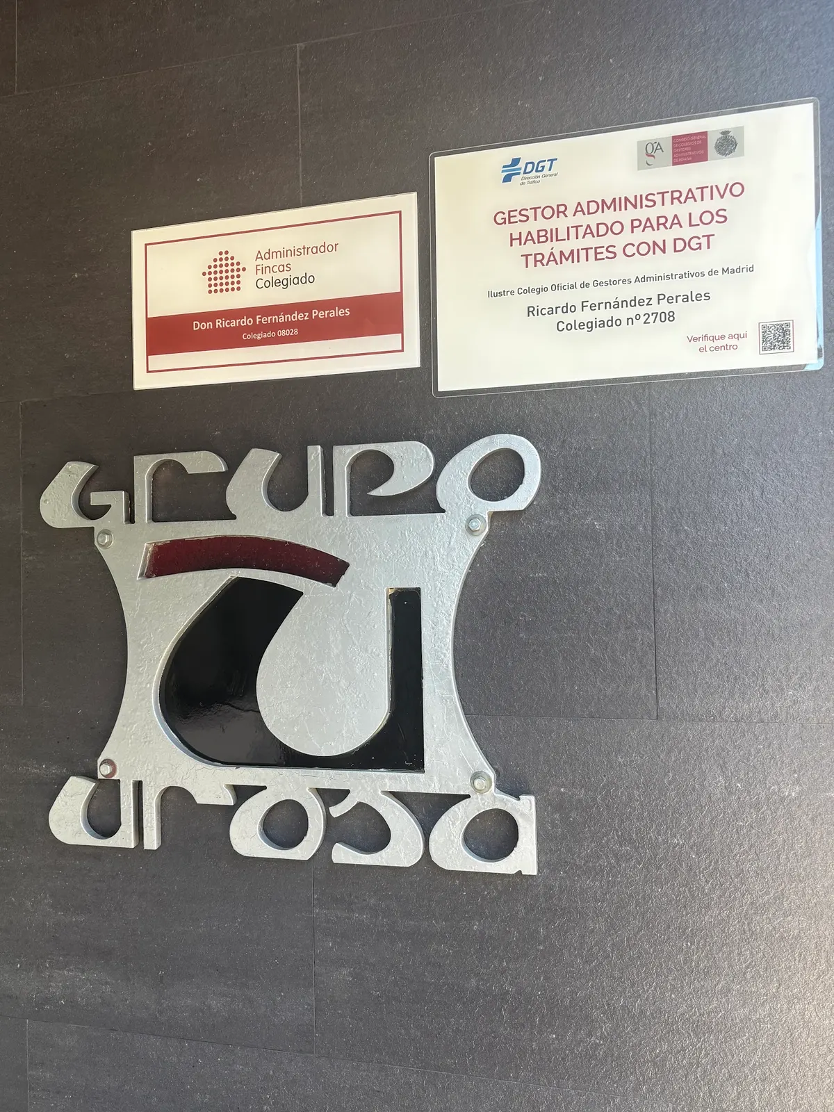 Logotipo metálico «Grupo Urosa» junto a las placas de administrador de fincas colegiado y de gestor habilitado para trámites con la DGT